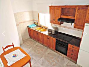 塔扎克蒂Apartamento El Tejar的厨房配有木制橱柜和炉灶烤箱。
