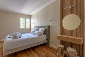 派拉索梅O'DUNE Pyla Plage -appartement jacuzzi vue mer -的一间卧室配有一张带镜子和凳子的床