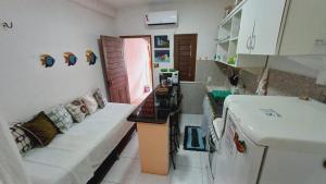 特赖里Casinha guagiru的带沙发的客厅和带冰箱的厨房。