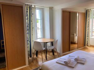 滨海科勒维尔La Suite Le Nôtre的卧室配有一张床和一张桌子及椅子