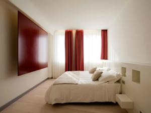 莱切Eos Hotel的卧室配有白色的床和窗户。