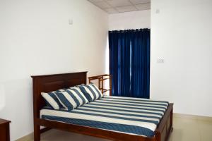 亭可马里Catamaran6 Guest Inn的一间卧室配有一张蓝色窗帘的床
