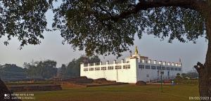 拉明德The Lumbini Village Lodge的一座白色的大建筑,公园里有塔