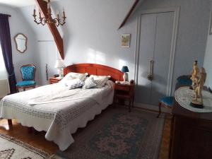 莱伊河畔圣米歇尔卡尼尔别墅的一间卧室配有一张床和两张蓝色椅子