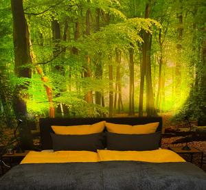 比勒费尔德Wood-Appartement的卧室的墙上挂有森林壁画