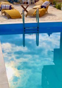 德拉格MiaBella Resort的一个带椅子的游泳池,水中反射天空