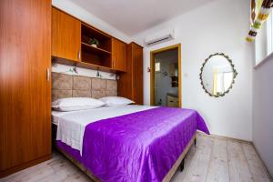 珀德垂那尼诺公寓的一间卧室配有一张紫色的床和镜子