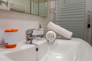 珀德垂那尼诺公寓的浴室水槽配有水龙头和一卷纸巾