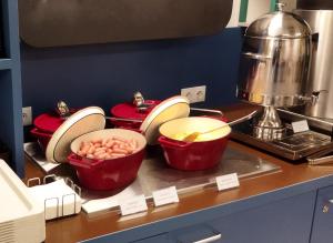布达佩斯NETIZEN Budapest Centre的厨房配有4个红色锅碗瓢盆,位于柜台上