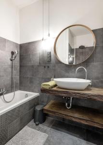 布达佩斯Industrial Fantasy Apartment的一间带水槽、浴缸和镜子的浴室