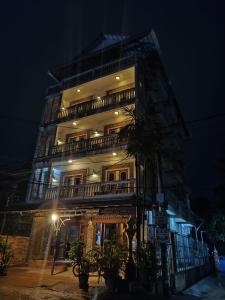 暹粒Beat Hotel Siem Reap的一座高大的建筑,晚上有一座建筑