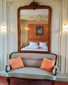 狄拉克Domaine du Châtelard的一张床上方的镜子,一张沙发放在房间里