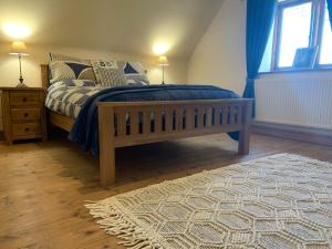 PlaishUpper Home Farm的一间卧室配有一张带蓝色毯子和地毯的床。