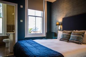 伯恩茅斯No5 Durley Road - Contemporary serviced rooms and suites - no food available的一间卧室设有一张大床和一个窗户。