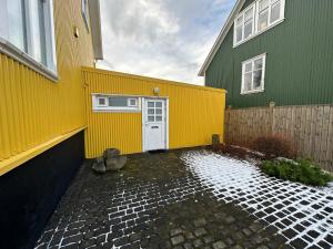 雷克雅未克An elegant studio apartment in Reykjavik - Great Location的黄色和绿色的建筑,有白色的门
