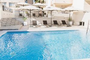 阿尔比尔Nacavi Albir Aparthotel的游泳池,带椅子和遮阳伞