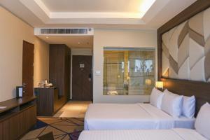 马尼拉鲁克森特酒店的配有一张床和一张书桌的酒店客房