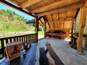 萨拉热窝Mysterylodge Bjelašnica Treskavica的木门廊设有长凳和吊床