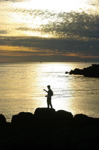 埃尔盖加贝里克A l'Ombre des Pommiers的一个人站在海洋的岩石上