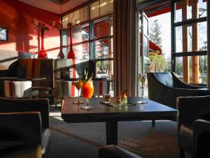 波城Hotel Parc Beaumont & Spa Pau - MGallery的餐馆里一张桌子上摆着两瓶花