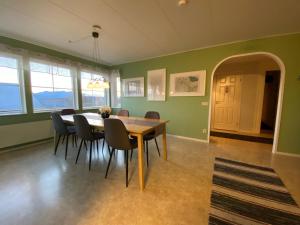 阿比斯库Lovely house in Abisko的一间拥有绿色墙壁和木桌及椅子的用餐室