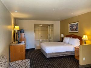 圣何塞SureStayPlus Hotel by Best Western San Jose Central City的酒店客房,配有床和电视