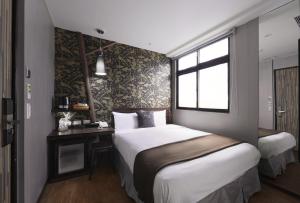 基隆香草艺术旅店的一间卧室设有两张床、一张桌子和一个窗口。