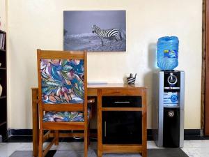 纳库鲁Splendid stay in Nakuru的一张桌子、一把椅子和墙上的斑马图