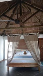 Bain BoeufBrahmanhut - Eco Hut experience in harmony with nature, wellbeing and spirit的配有吊扇的客房内的一张床位