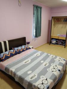 怡保QQ Homestay的一间卧室配有一张带蓝色棉被的大床
