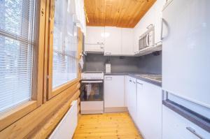 列维Reininlaakso Ainola的厨房配有白色橱柜和窗户。