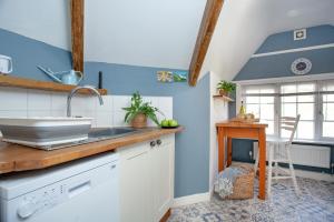 巴德利索尔特顿The Roost的厨房设有蓝色的墙壁、水槽和桌子