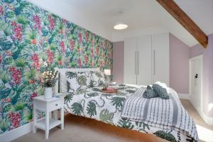 巴德利索尔特顿The Roost的一间卧室配有一张带热带壁纸的床