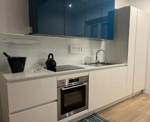 罗马Interno 4 - Luxury Holiday Rome的厨房配有白色橱柜、水槽和炉灶。
