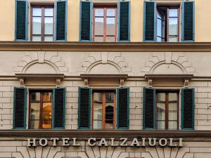 佛罗伦萨FH55 Hotel Calzaiuoli的一座带绿色百叶窗的建筑和一家酒店