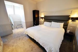 伦弗鲁Glynhill Hotel & Spa near Glasgow Airport的卧室设有一张白色大床和一扇窗户。