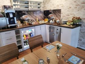 滕宁Gästehaus Arkona的厨房配有桌子和冰箱