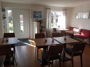 滕宁Gästehaus Arkona的用餐室配有木桌和椅子