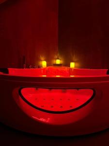 卢森堡LOVE ROOM - Luxembourg的深色的客房内的红色浴缸,配有床
