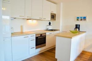 奥茨塞巴德·迪尔哈根Buhne 10 App Nr 26 max 2 Pers的厨房配有白色橱柜和台面