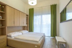 奥茨塞巴德·迪尔哈根DUENENROSE App Nr 03 max 3 Pers的一间卧室设有床铺和一个带绿色窗帘的窗户。