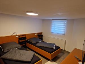 穆更斯托姆Monteurzimmer-mit GemeinschaftsBad und Küche BEI RASTATT的小房间设有两张床和窗户