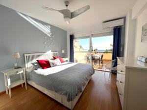 卡博皮诺Duplex-Townhouse en Marbella - vistas al mar -sea view的一间卧室配有一张带红色枕头的床和一个阳台