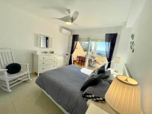 卡博皮诺Duplex-Townhouse en Marbella - vistas al mar -sea view的卧室配有床、椅子和窗户。