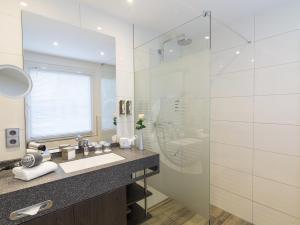 汉诺威莱讷宫康库德酒店的一间带水槽和玻璃淋浴的浴室