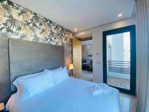 卡萨布兰卡Mogador Presidential Terrace - By AppartAli的卧室设有白色的床和大窗户
