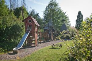奥斯特罗德Tiny House Pioneer 5 - Green Tiny Village Harz的公园内一个带滑梯和长凳的游乐场