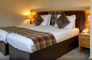 德里门Buchanan Arms Hotel & Leisure Club的酒店客房 - 带一张大床和两个枕头