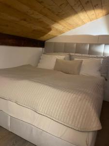 卡斯拉诺Elegantes Haus in der Altstadt Caslano的一张带白色床单和枕头的床