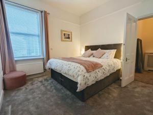 索尔泰尔Charming Victorian Home in Saltaire的一间卧室设有一张大床和一个窗户。